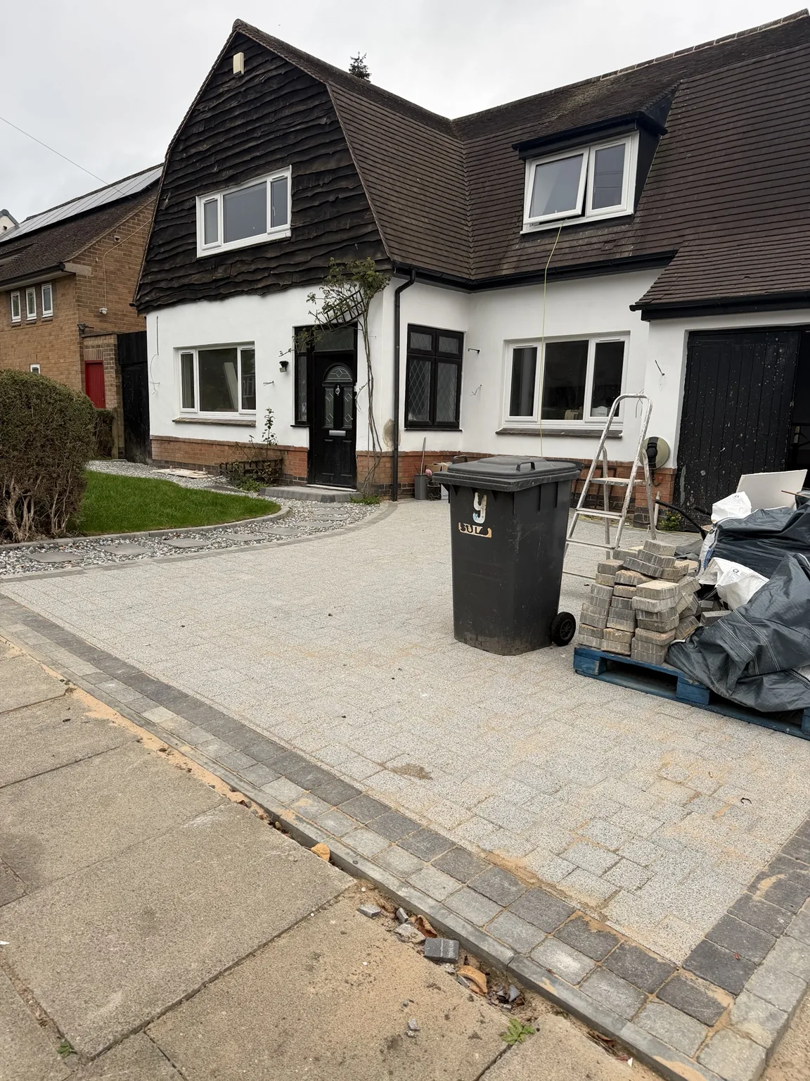 Completed block-paved driveway with charcoal edging outside the house