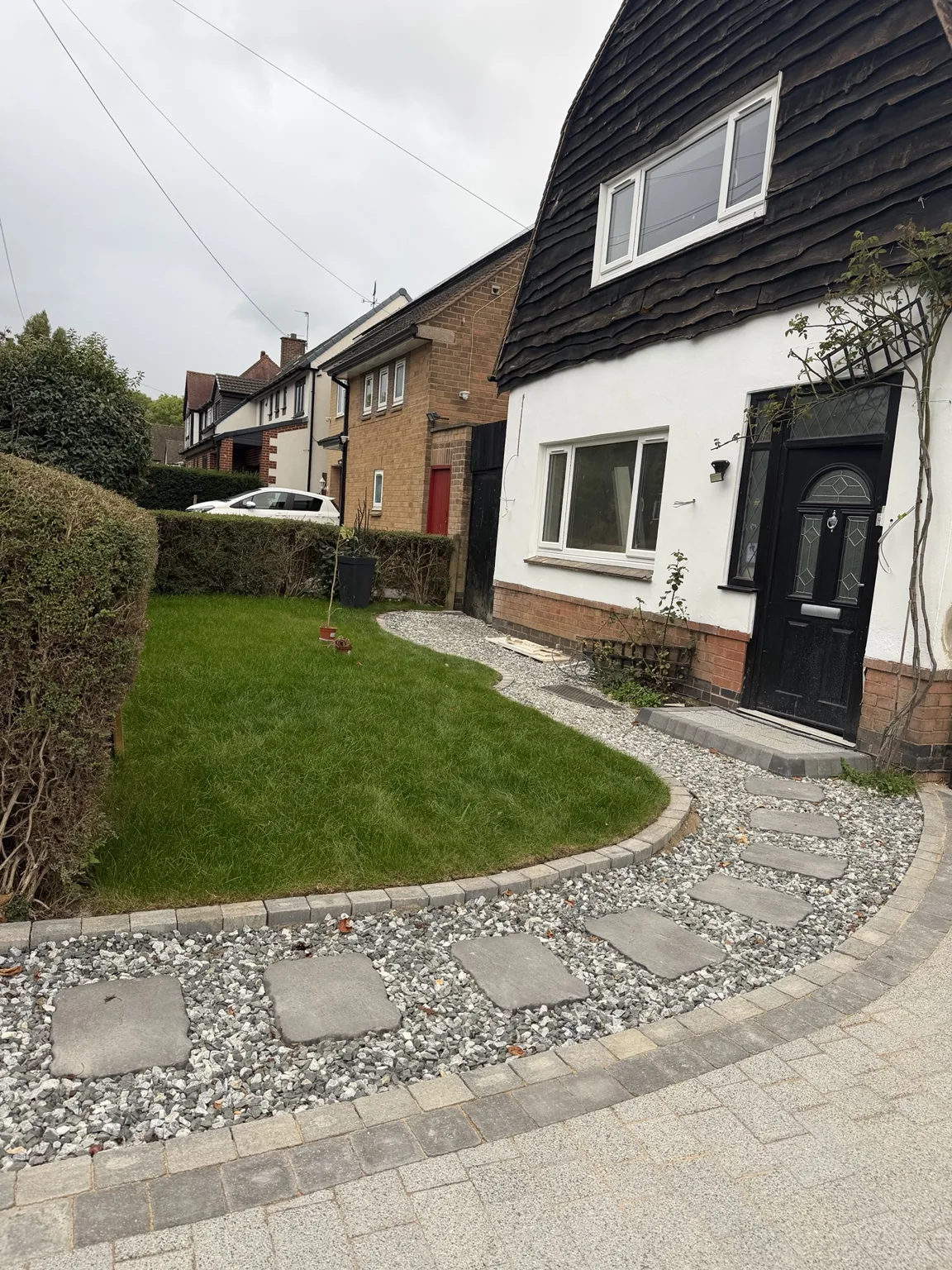 Curved stepping-stone path through gravel beside the fresh front lawn
