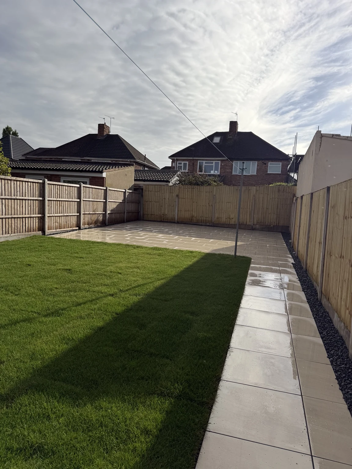 Completed lawn and porcelain paving viewed across the garden