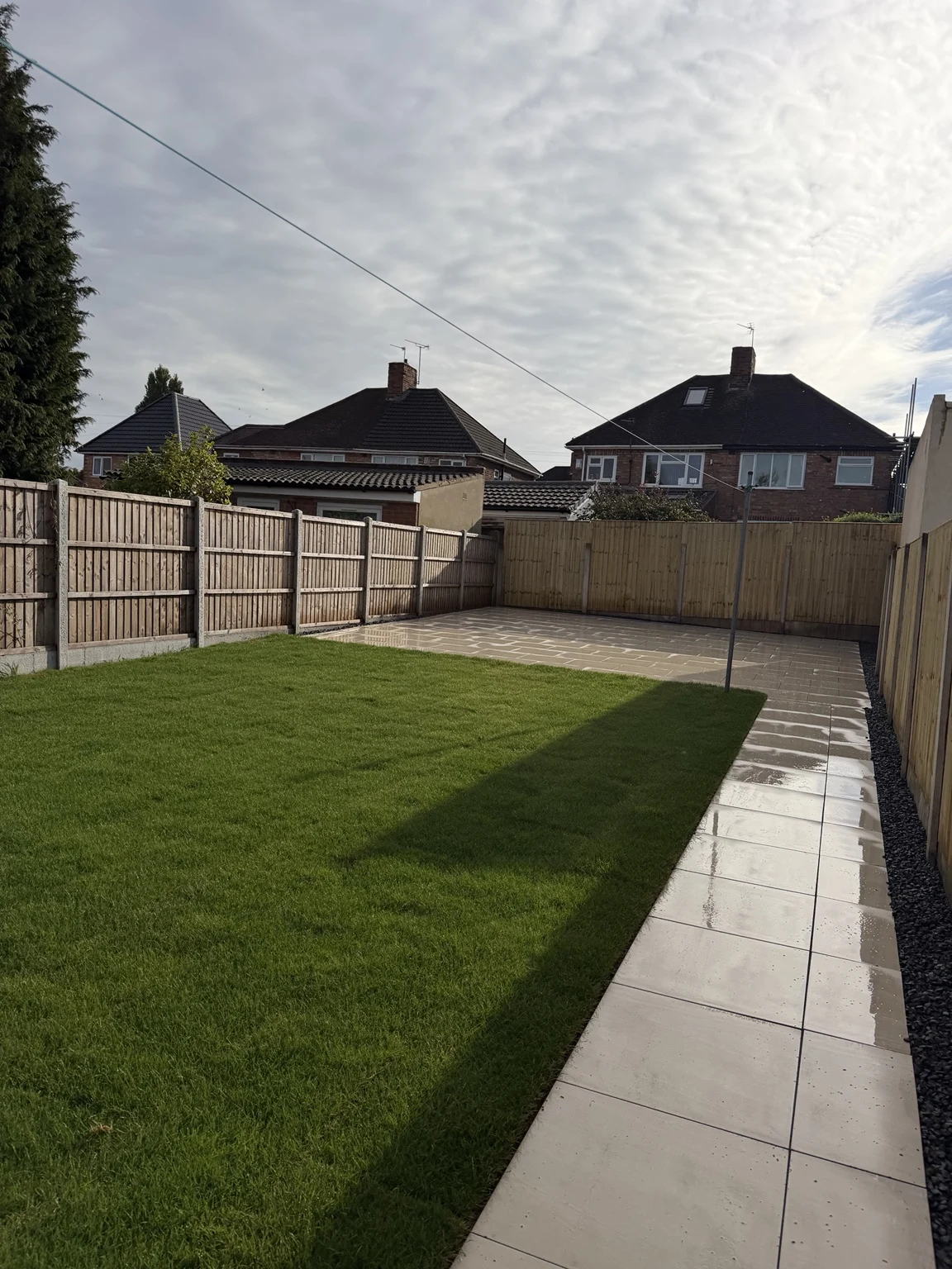 Finished lawn with porcelain pathways and fencing