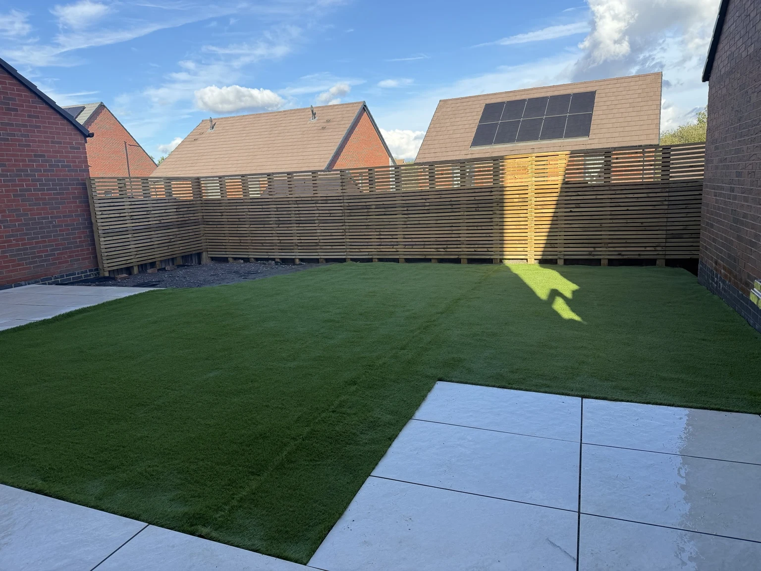 Completed garden with Venetian fencing, artificial turf and porcelain patio