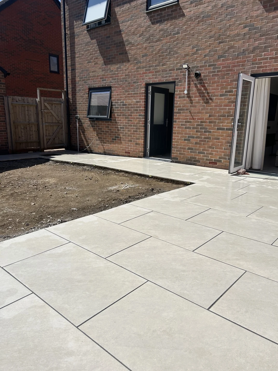 New porcelain paving beside the house before the turf and fencing were installed
