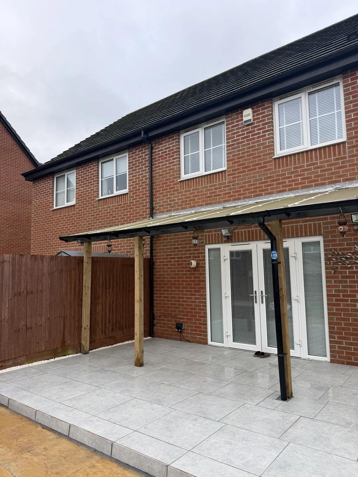 Completed porcelain patio with tiled sides and replacement lean-to posts in Humberstone