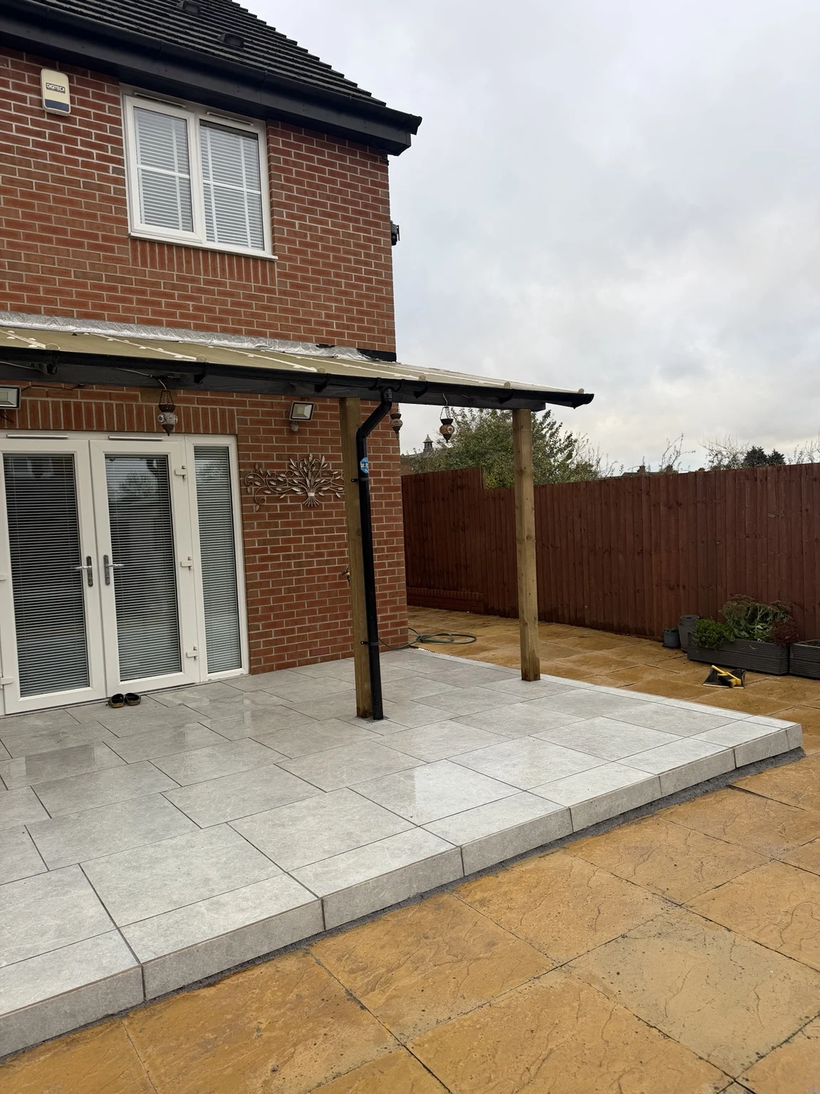 Finished grey porcelain patio beneath the existing lean-to